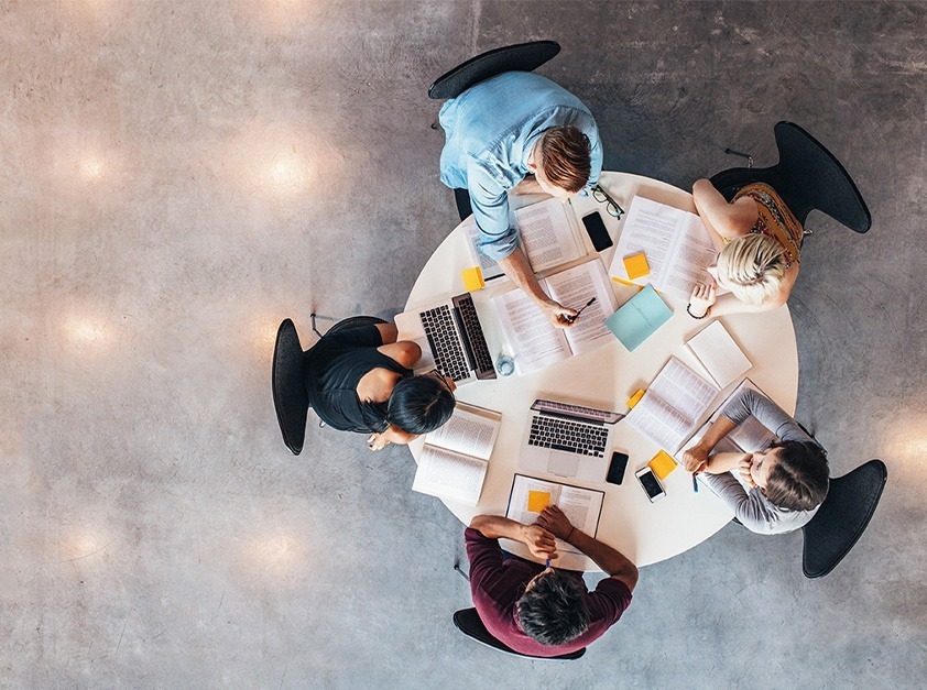 Top down view of people sitting around an office table