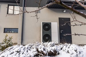 A heat pump in the winter with snow around