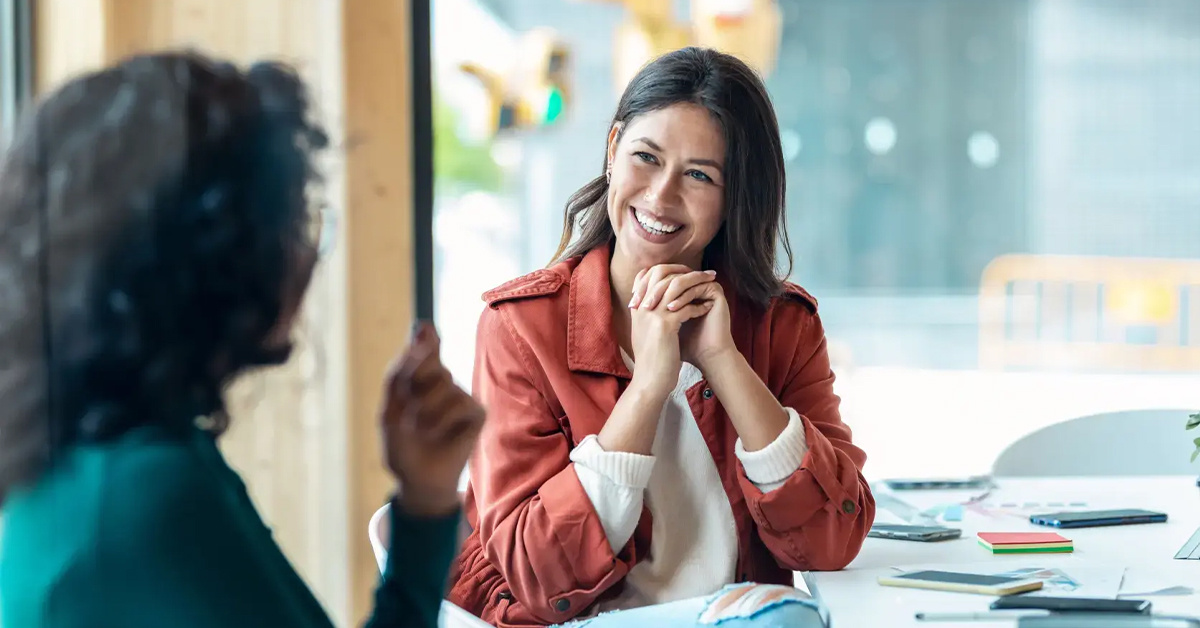 woman smiling whilst talking at table