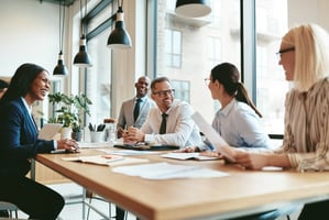 Group of people sitting around a table collaborating and working together