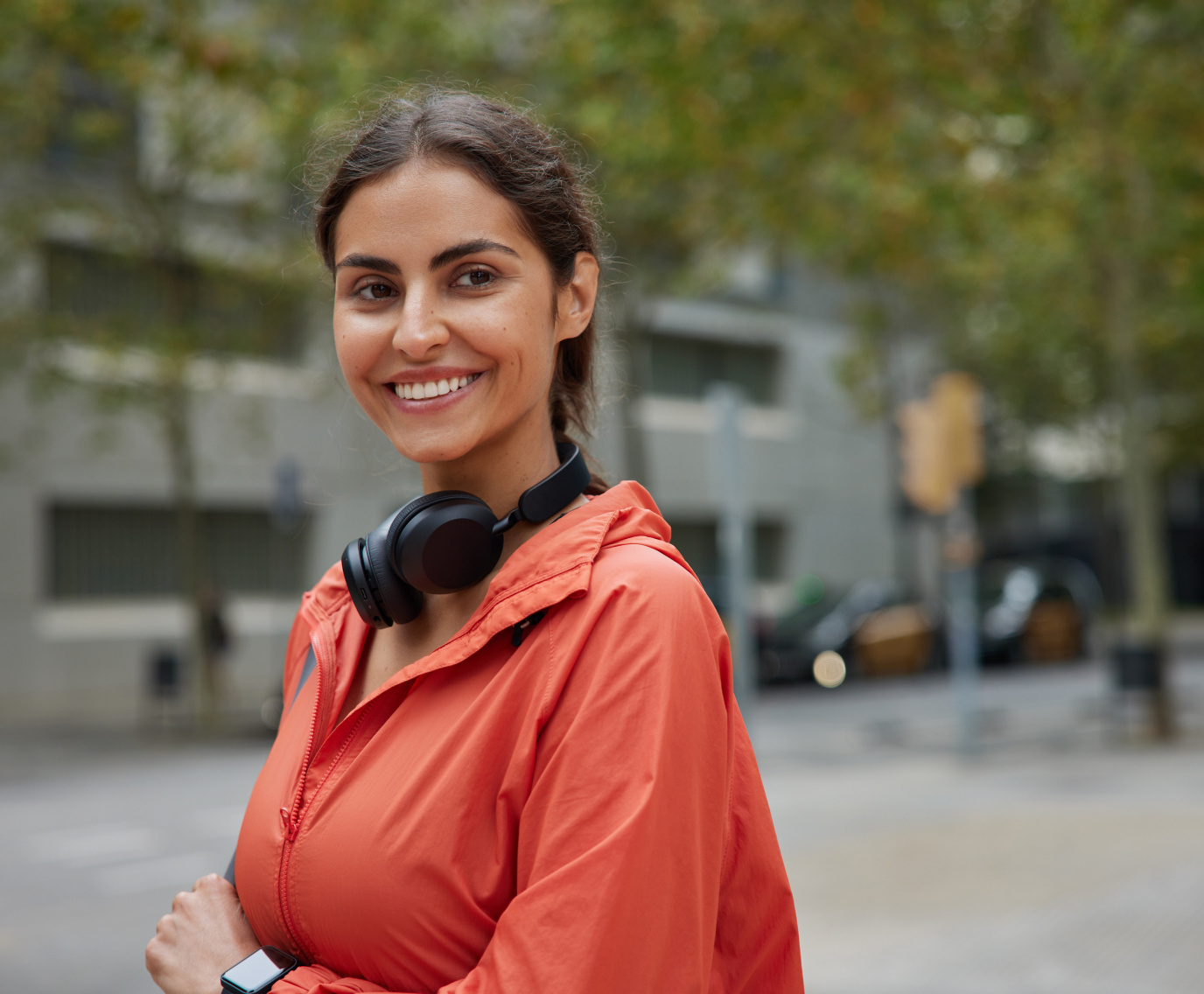 Woman with headphones smiling on the street