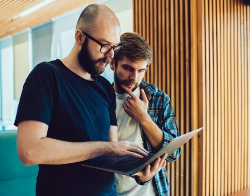 two men looking at ipad
